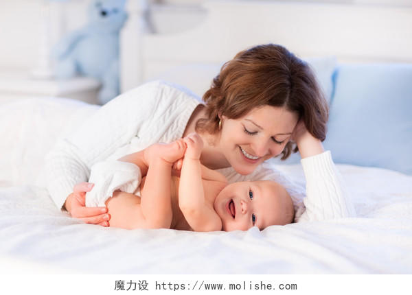 卧室里白色床上开心的母亲和孩子